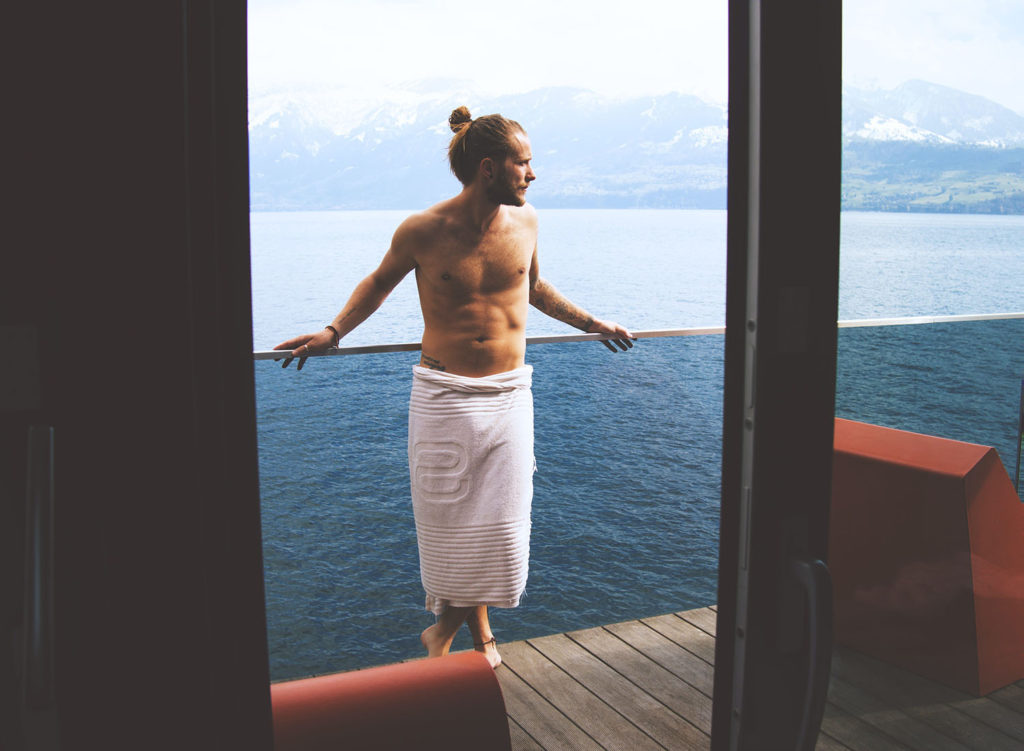 Man with a towel wrapped around his waist waiting at the sauna